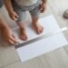 Parent accurately measuring a toddler’s foot for a toddler shoe size chart by age in cm